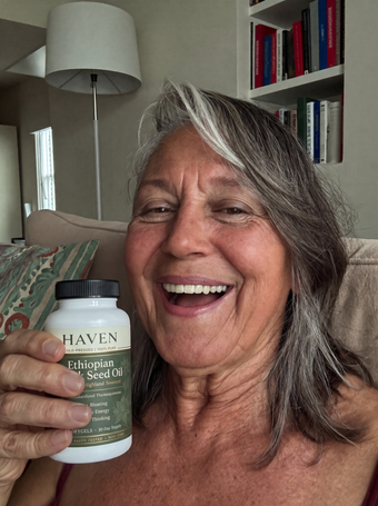 Customer holding Haven Black Seed Oil at home