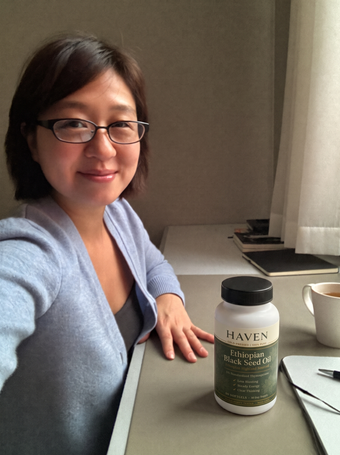 Customer with Haven Black Seed Oil on her desk